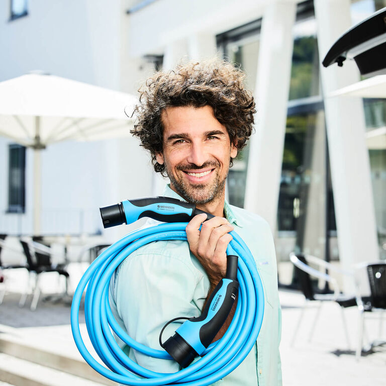 Mann mit MENNEKES Ladekabel Typ 2 Mode 3